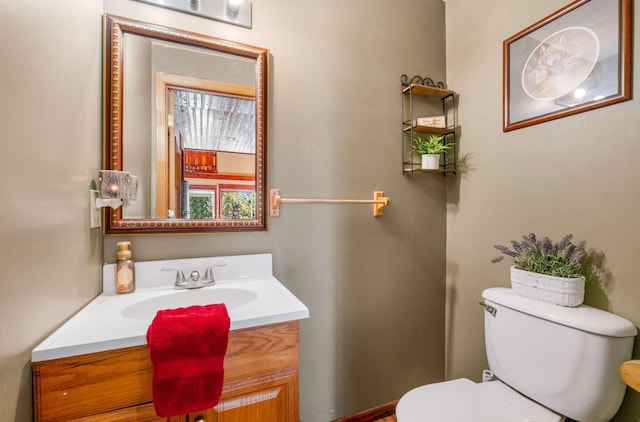 half bathroom featuring vanity and toilet