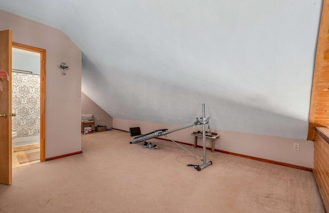 workout area featuring vaulted ceiling, carpet, and baseboards