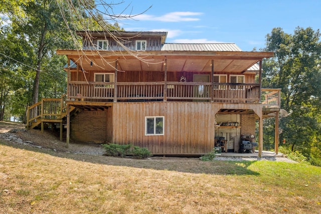 back of house featuring a wooden deck, stairs, metal roof, and a yard