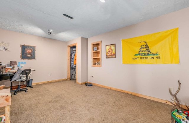 carpeted office space featuring a textured ceiling and baseboards