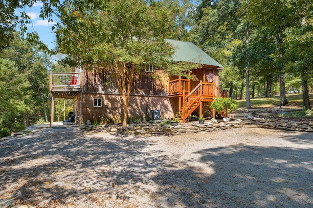 exterior space with metal roof, a deck, and stairs