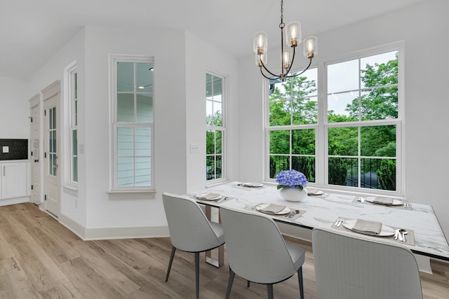 dining space featuring a healthy amount of sunlight, a notable chandelier, and wood finished floors