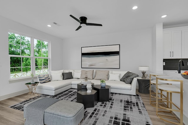 living area featuring light wood finished floors, ceiling fan, visible vents, and recessed lighting