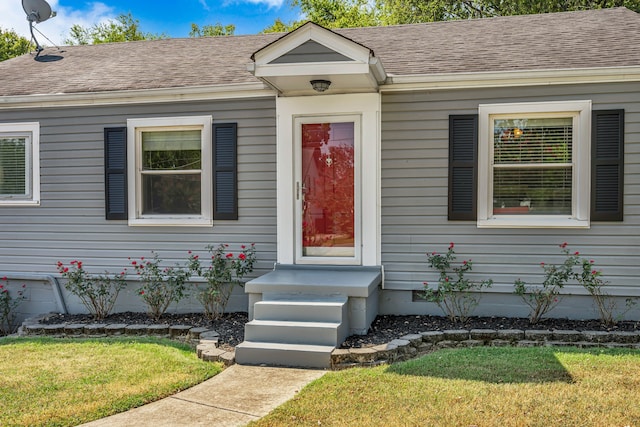 entrance to property with a lawn