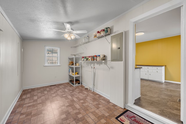 interior space featuring wooden walls, ornamental molding, a textured ceiling, electric panel, and ceiling fan