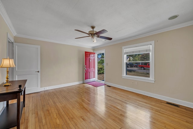 empty room featuring a textured ceiling, crown molding, ceiling fan, and light wood-type flooring