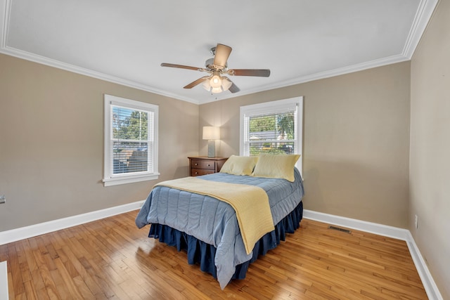 bedroom with ceiling fan, wood-type flooring, and multiple windows