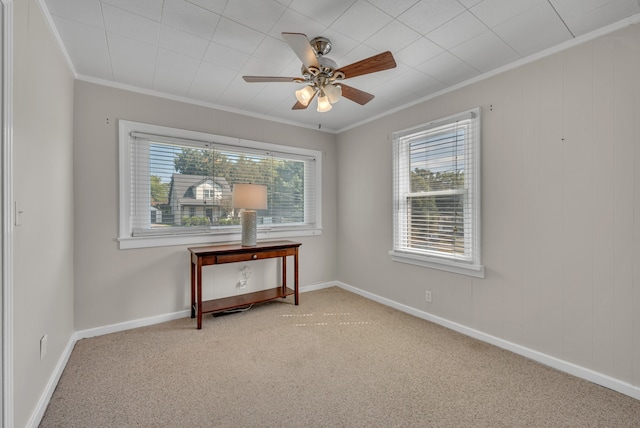 carpeted spare room with crown molding and ceiling fan