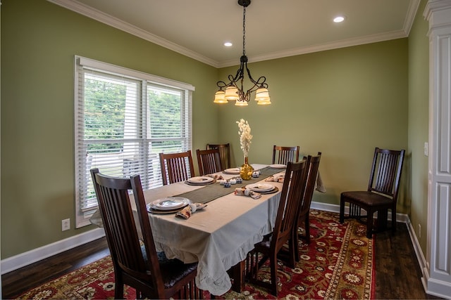 dining space featuring dark hardwood / wood-style floors, an inviting chandelier, and ornamental molding