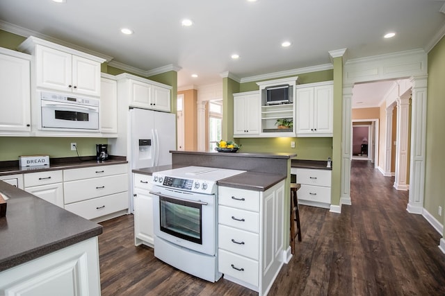 kitchen featuring a kitchen island, ornamental molding, white appliances, and dark hardwood / wood-style flooring