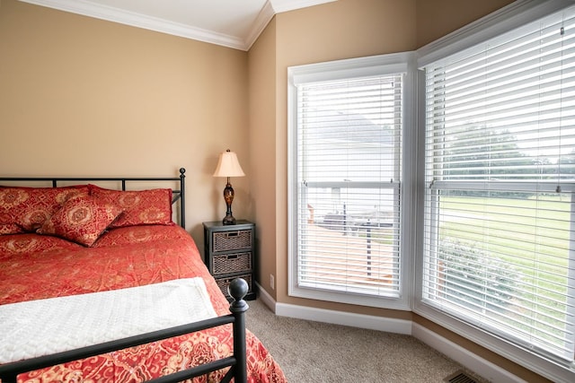 carpeted bedroom with ornamental molding and multiple windows