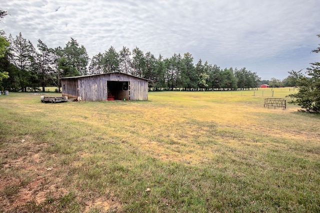 view of yard with a rural view and an outdoor structure