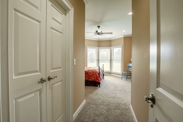 corridor featuring crown molding and light carpet