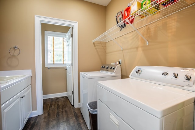 laundry area featuring dark hardwood / wood-style flooring, cabinets, and washer and clothes dryer