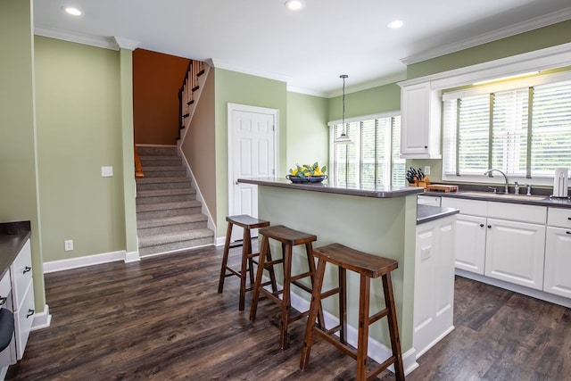 kitchen with a center island, sink, decorative light fixtures, and white cabinetry