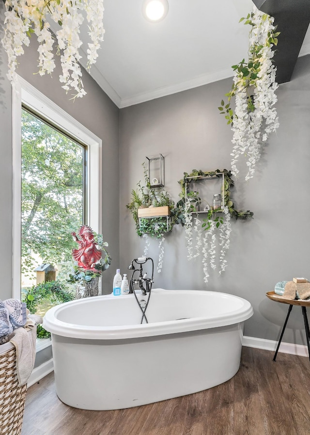 full bathroom with crown molding, a soaking tub, wood finished floors, and baseboards