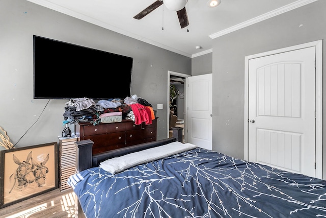bedroom with ceiling fan, wood finished floors, and ornamental molding