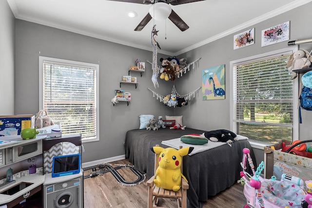 bedroom with ceiling fan, baseboards, wood finished floors, and crown molding