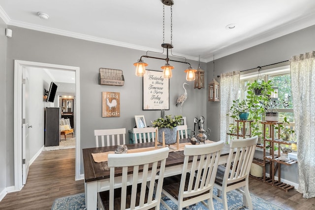 dining area with crown molding, wood finished floors, and baseboards