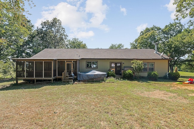 rear view of property with a yard and a sunroom