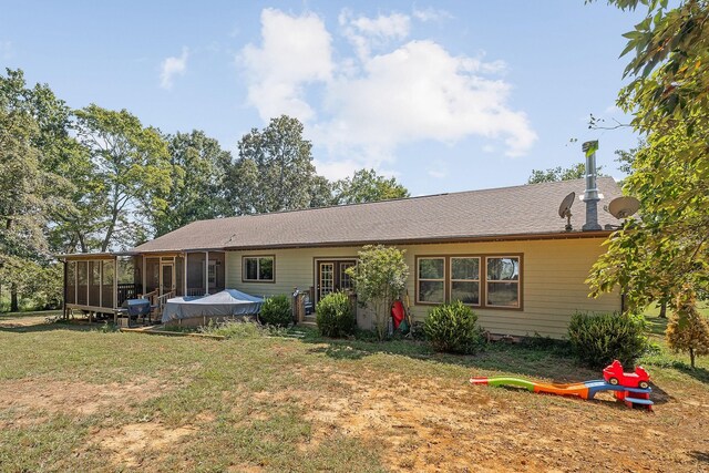 rear view of property with a lawn and a sunroom