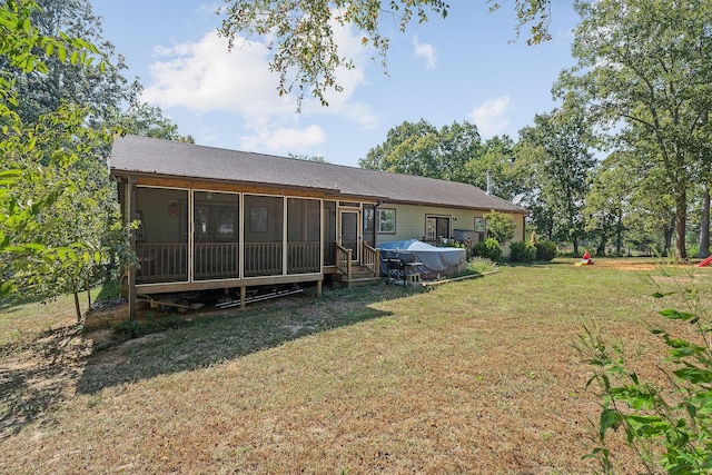back of property featuring a lawn and a sunroom
