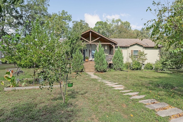 view of front of property featuring a front yard and a vegetable garden