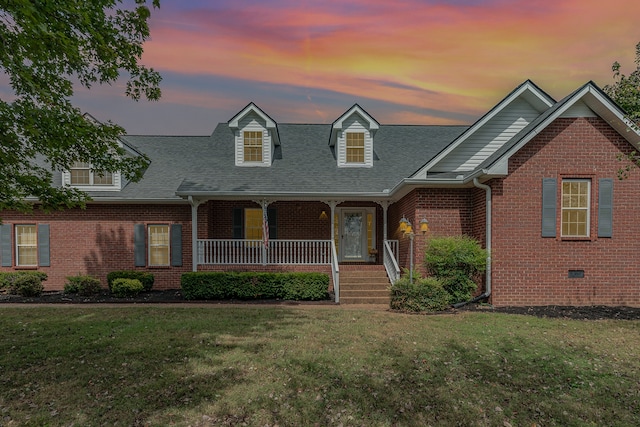 view of front of home featuring covered porch and a yard