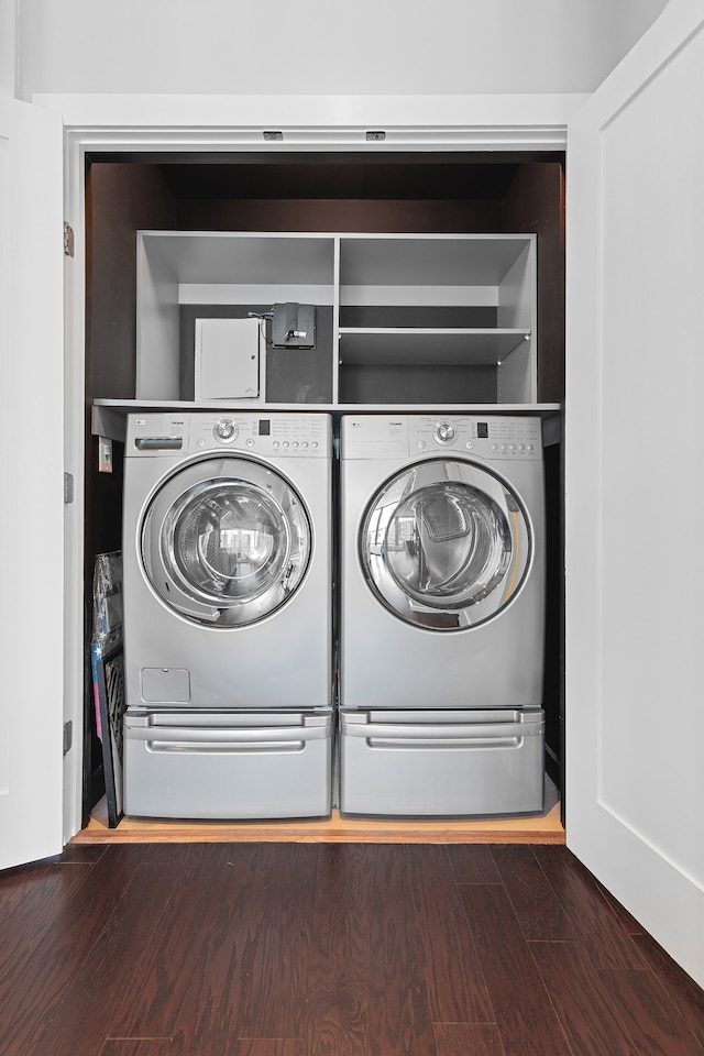 laundry room featuring washing machine and clothes dryer and dark hardwood / wood-style floors