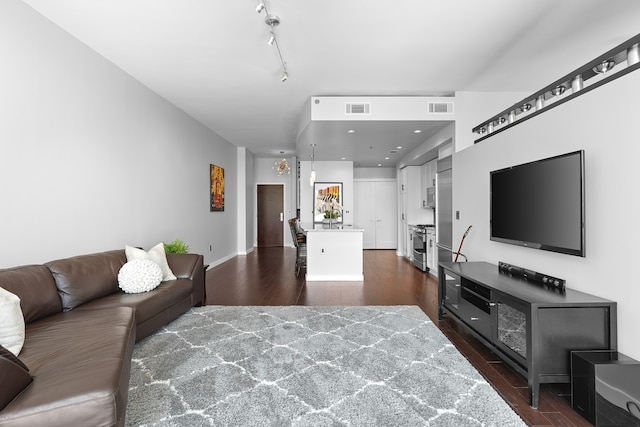 living room with dark wood-type flooring and track lighting