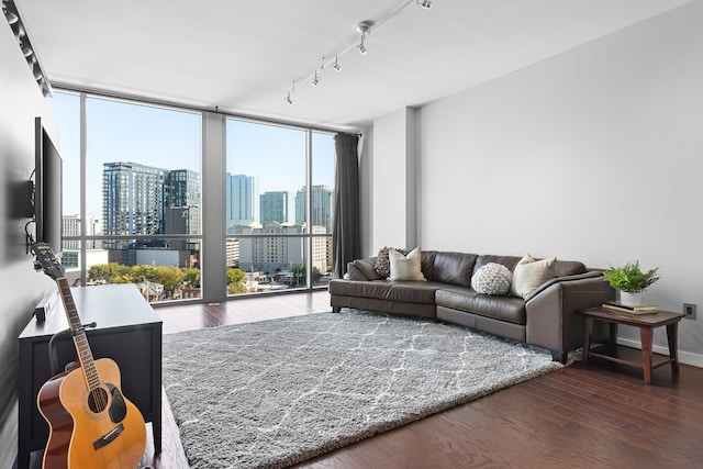 living room with dark wood-type flooring, floor to ceiling windows, plenty of natural light, and track lighting