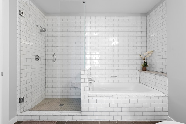 bathroom featuring hardwood / wood-style floors and plus walk in shower