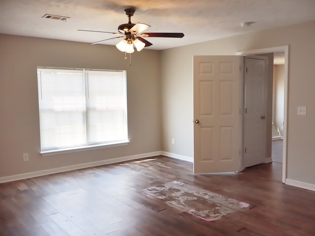 empty room featuring dark wood-type flooring and ceiling fan