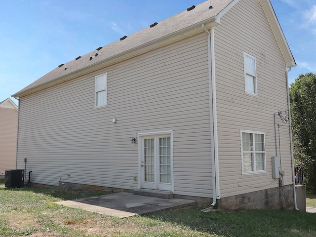 rear view of house with a lawn, cooling unit, and a patio