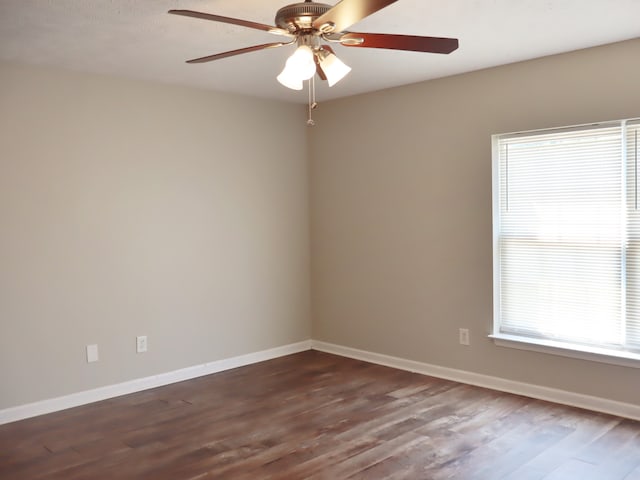 empty room with ceiling fan and dark hardwood / wood-style flooring