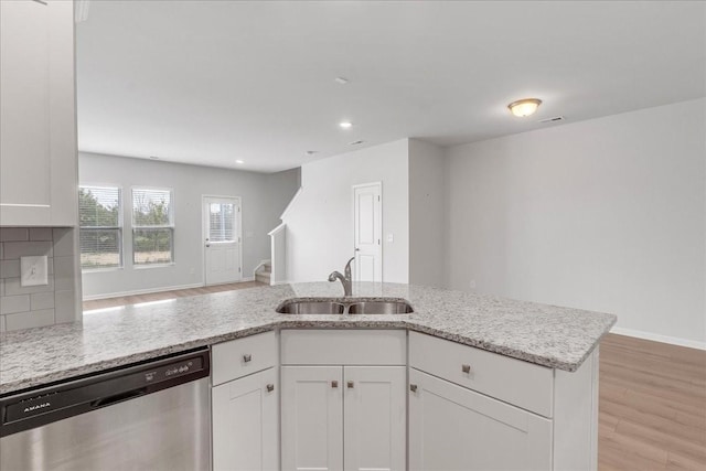 kitchen featuring a sink, light stone countertops, white cabinets, and stainless steel dishwasher