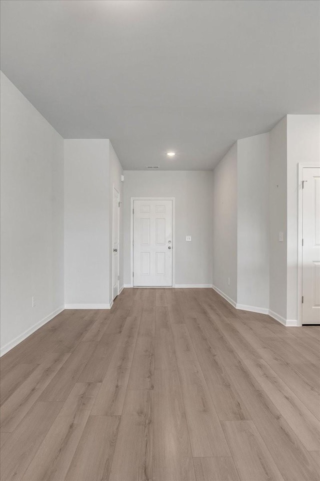 unfurnished room with baseboards, visible vents, and light wood-style floors