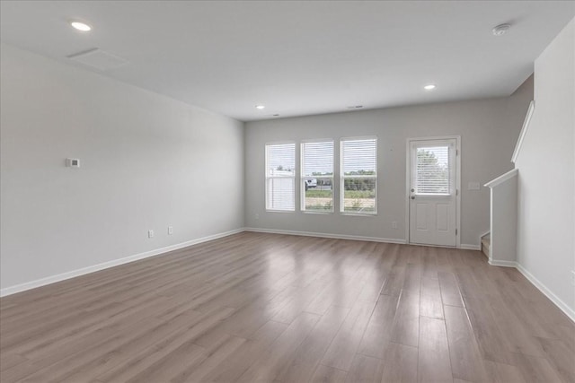 unfurnished living room featuring baseboards, wood finished floors, and recessed lighting