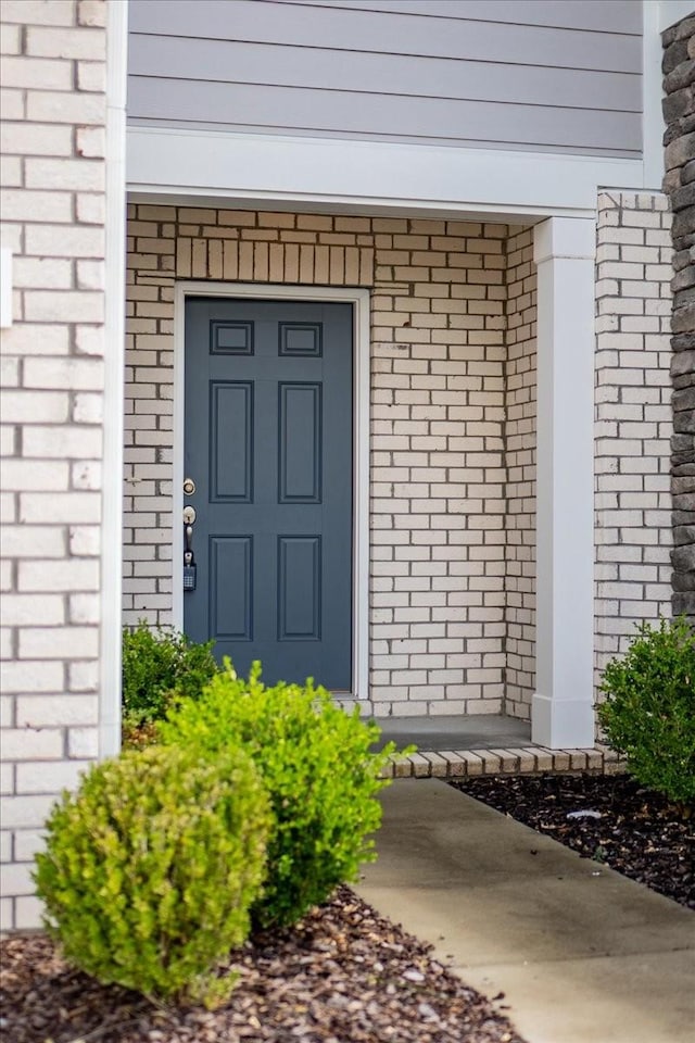 property entrance featuring brick siding