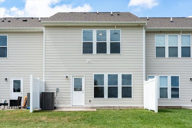 back of house featuring cooling unit and a yard