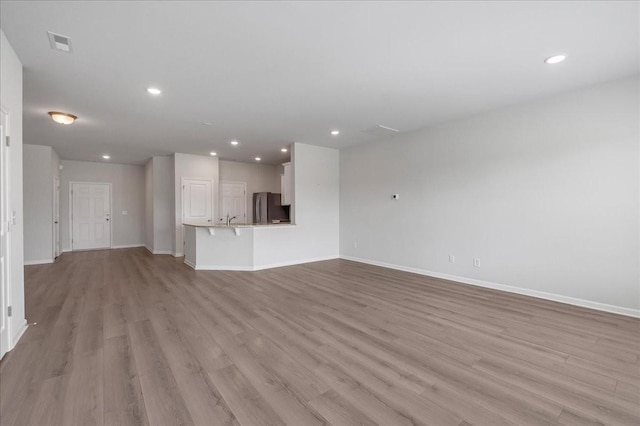 unfurnished living room with baseboards, recessed lighting, visible vents, and light wood-style floors