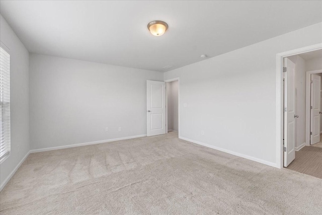 empty room featuring carpet floors and baseboards