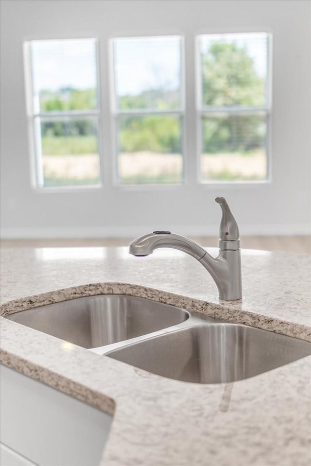 details with a sink and light stone countertops