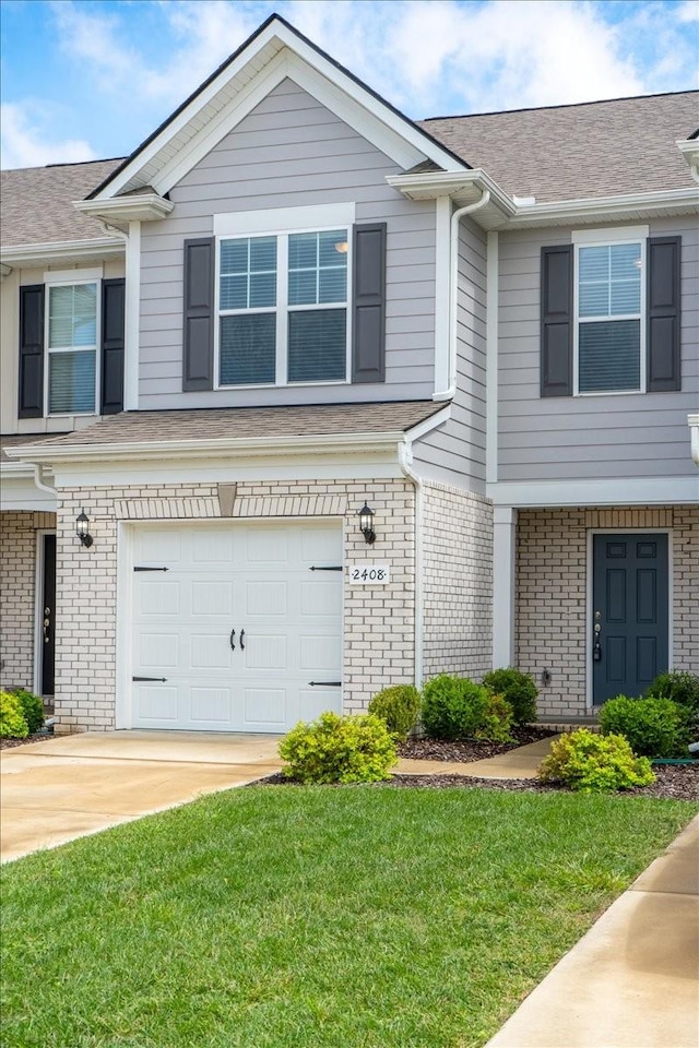 view of property with brick siding, a shingled roof, a front yard, a garage, and driveway