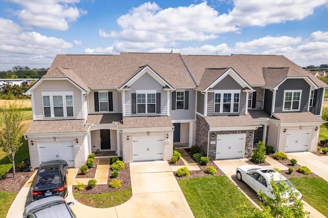 view of front of house with a garage, brick siding, and driveway