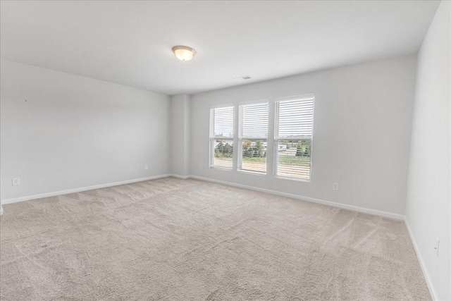 carpeted empty room featuring visible vents and baseboards