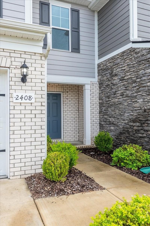 doorway to property with brick siding