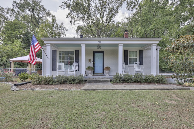 neoclassical home featuring a front lawn and covered porch