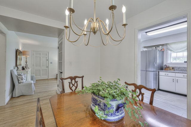 dining space with a chandelier and light hardwood / wood-style floors