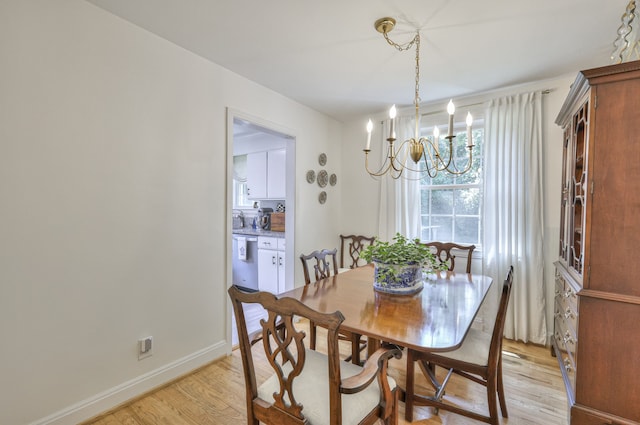 dining area with light wood-type flooring and a chandelier